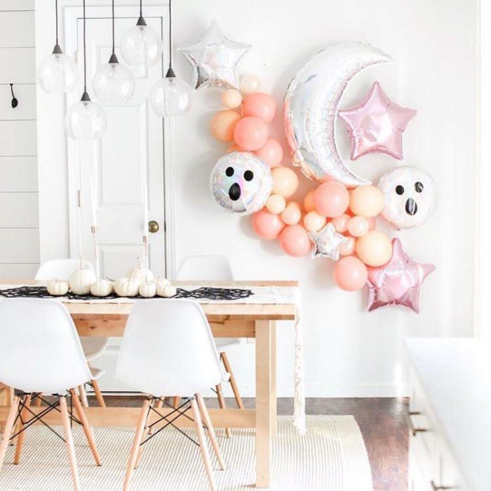 Comedor blanco decorado en la pared con globos de helio de fantasmas y luna