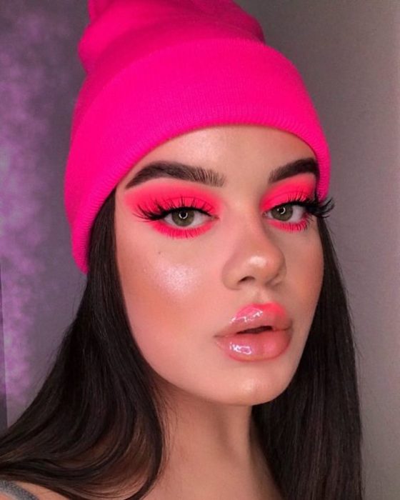 Chica morena de cabello largo oscuro con gorro y sombras rosa neón