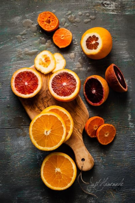 Naranja en rodajas para mascarilla facial sobre una tabla de madera 