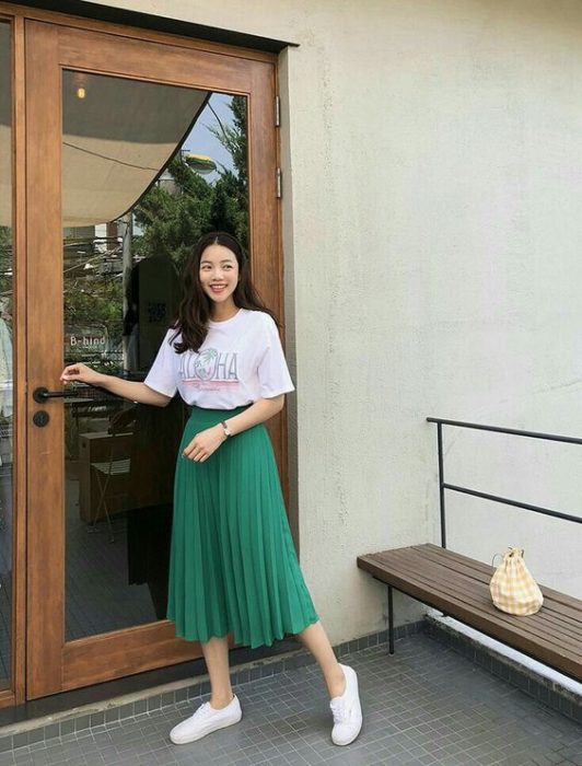 Mujer asiática con blusa larga oversize blanca y falda larga verde