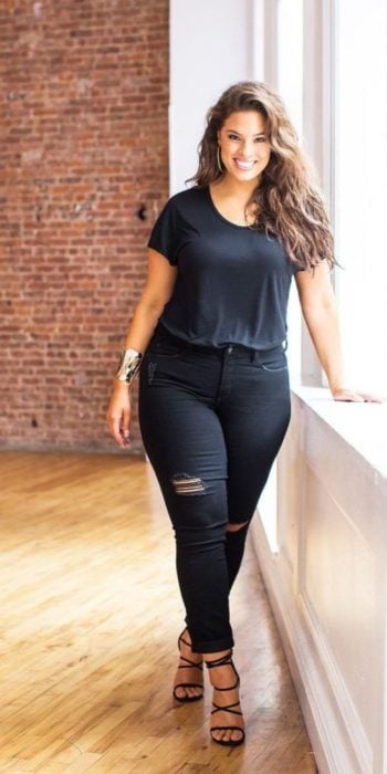 Chica usando un total black look de jeans rasgados blusa de manga corta y tacones