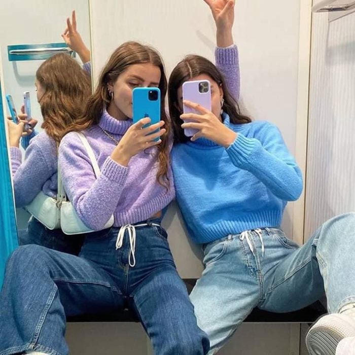 Chicas usando jeans y suéteres lila y azul