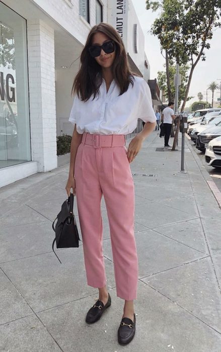 Chica usando outfit con detalles en baby pink en paper pants y blusa blanca, además de zapatos blancos