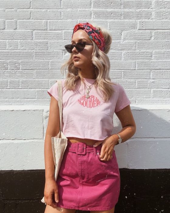 Chica usando outfit con detalles en baby pink en blusa top y falda rosa fucsia