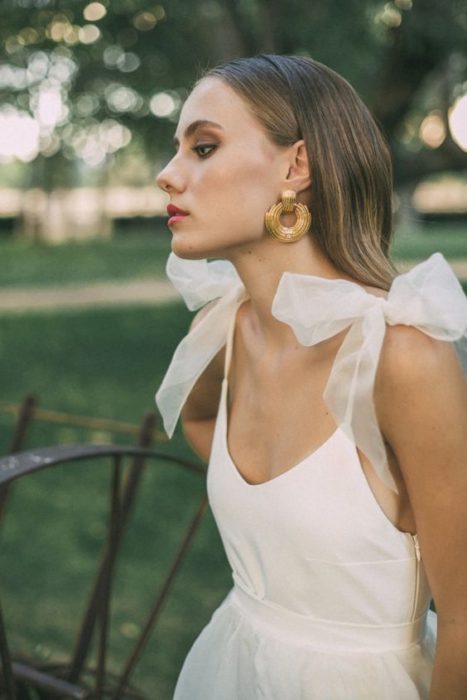 Chica con vestido de novia con tirantes de moños ampones