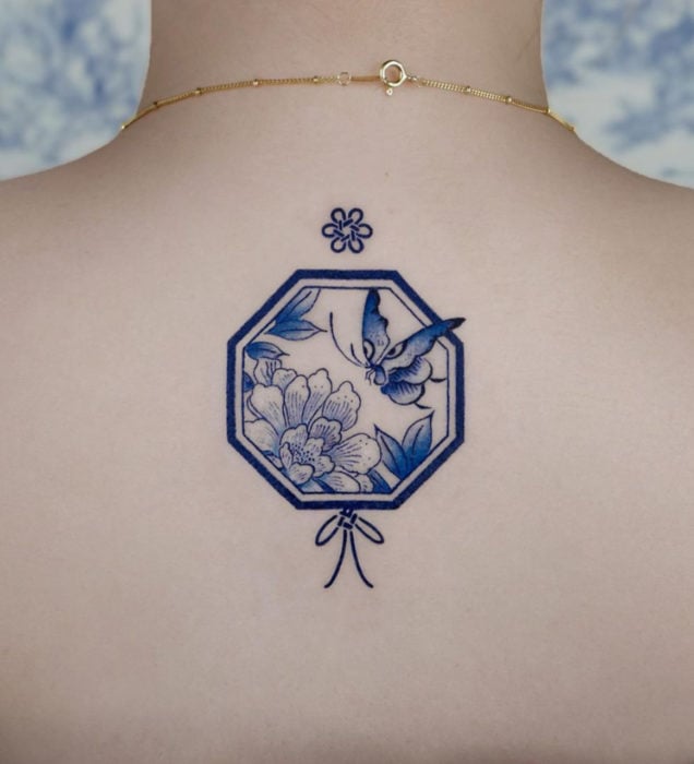 Tatuaje pequeño estilo japonés de tinta azul de flores y mariposa