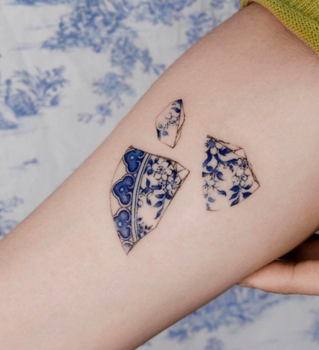Tatuaje pequeño estilo japonés de tinta azul de plato de porcelana roto en el brazo