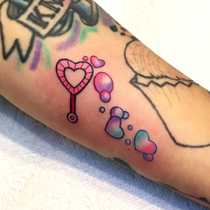 Tatuaje tierno kawaii en el brazo de soplador de burbujas en forma de corazón