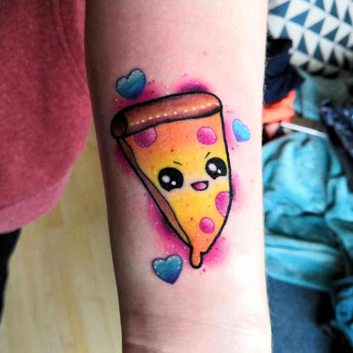 Tatuaje tierno kawaii en el brazo de pizza con carita enojada y corazones azules