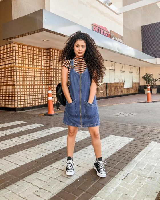 Vestido corto de color mezclilla con blusa de rayas debajo y vans