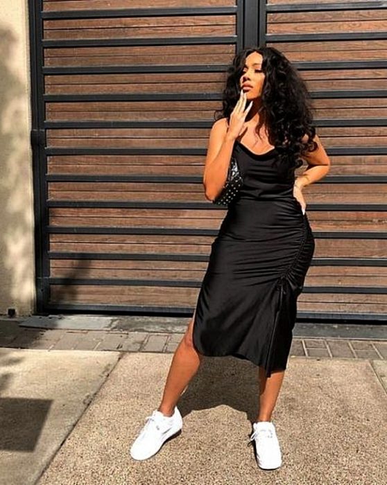 chica morena con cabello chino largo usando un vestido slip dress de satén con tenis deportivos negros