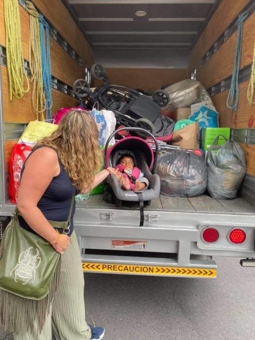 Camión lleno de artículos para bebé, comida y ropa que una familia recibió como ayuda 