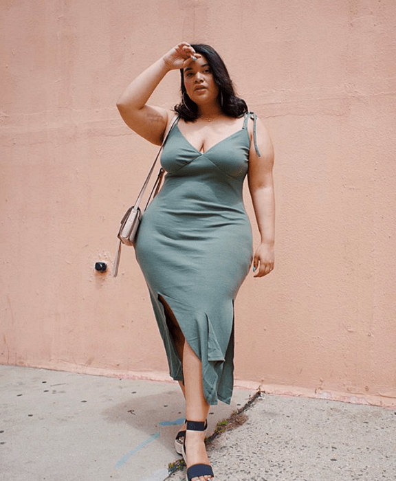 chica curvy usando un vestido color verde opaco gris con escote en V y tirantes