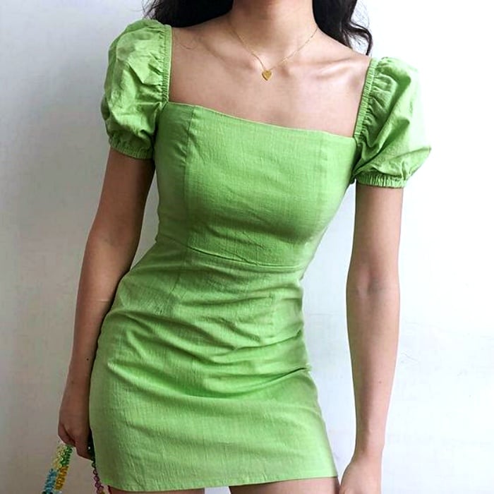 chica usando vestido verde brillante con escote cuadrado y mangas cortas