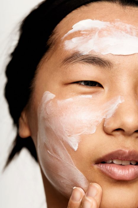 Chica aplicando crema facial