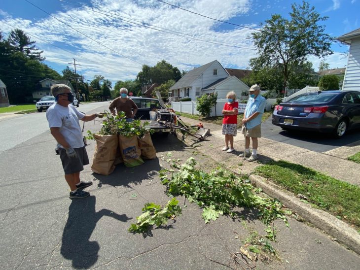 Brian Schwartz recogiendo ramas después de un trabajo de jardineria