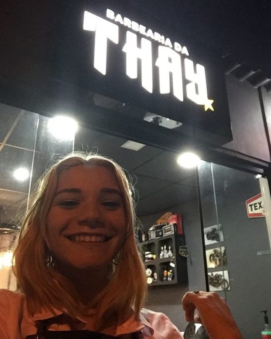 Thayssa tomando una selfie afuera de su barberia