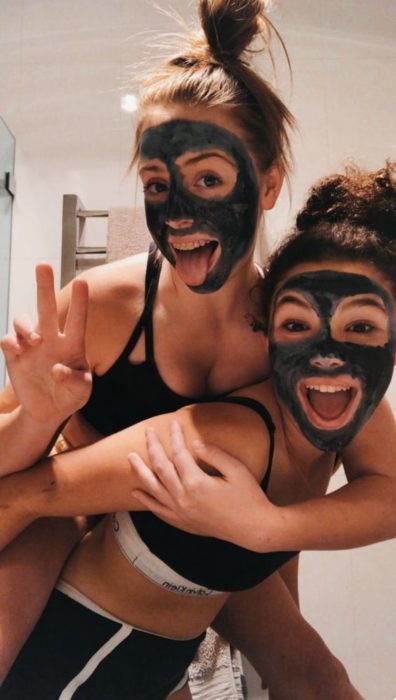 Chicas usando mascarilla de carbón activado