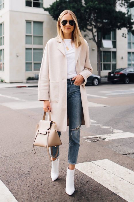 Chica caminando por las calles mientras usa unos botines de color blanco