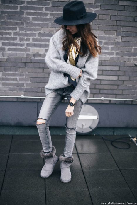 Chica posando para una foto mientras usa un outfit de color gris con unas botas ugg del mismo color 