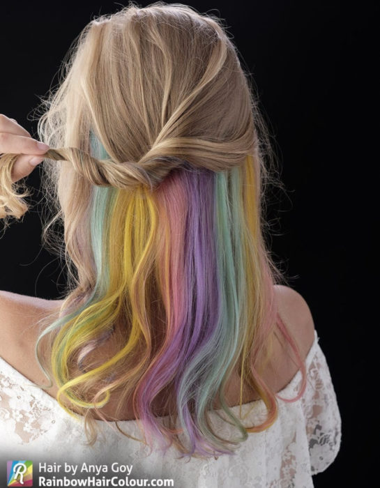 Mujer de cabello abajo de los hombros, ondulado, rubio cenizo teñido a la mitad de colores arcoíris pastel, azul, verde, amarillo, rosa y morado