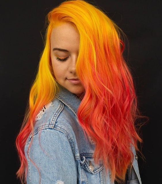 Chica con cabello larfo color amarillo en en el crecimiento y rojo en las puntas