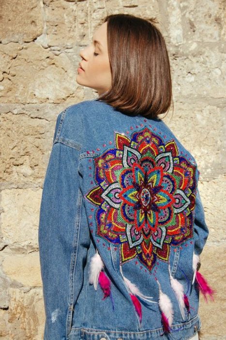 Chaqueta denim customizada con un mandala bordado en la zona de la espalda y algunas plumas en la parte inferior