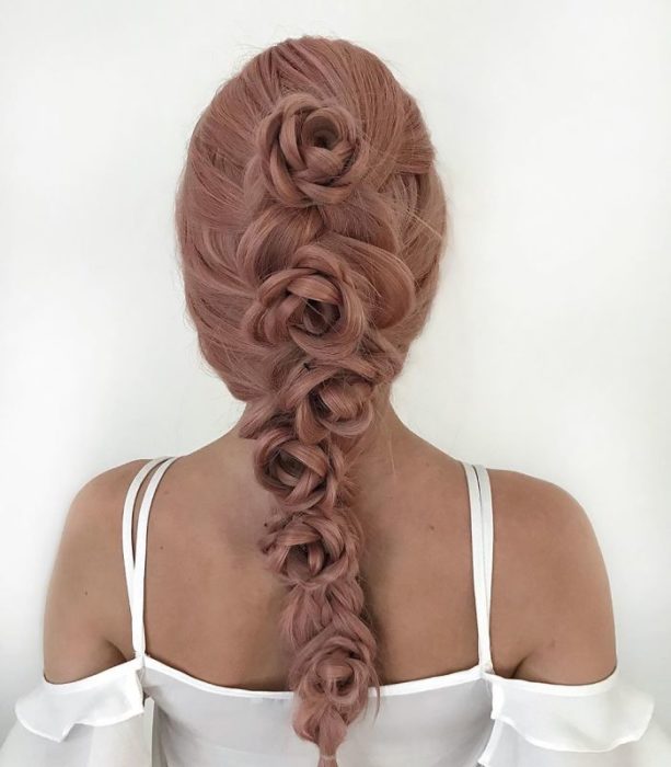 Chica con el cabello trenzado con diferentes rosas en forma de una cascada