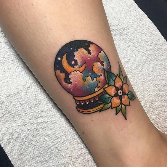 Tatuaje en forma de bola de cristal con una luna 