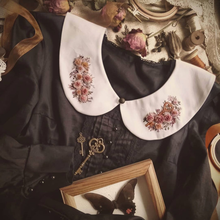 Amberry Lamb crea bonitos cuellos bordados de Halloween para vestidos y blusas; diseños de ramos de flores sobre tela blanca, vestido vintage negro; cuadro con mariposa disecada y llaves antiguas