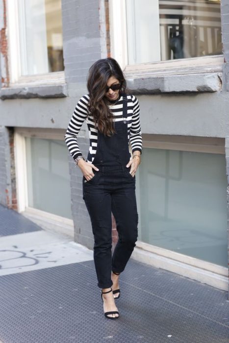 Chica de cabello largo ondulado con blusa de manga larga blanco con negro y overol