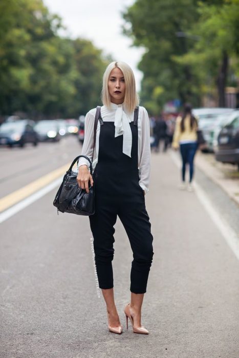 Chica rubia de cabello corto con overol negro con blusa blanca