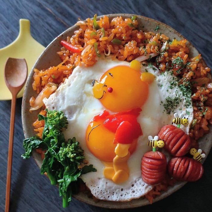 Platillo creador por la usuaria en Instagram Etoni Mama, plato de arroz con huevo estrellado en forma de Winnie-Pooh