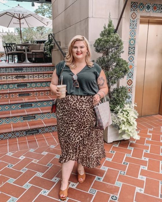 Chica plus size rubia con blusa verde militar y maxi falda de leopardo