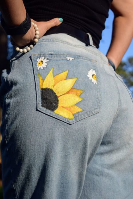 Chica llevando jeans con dibujo de girasol