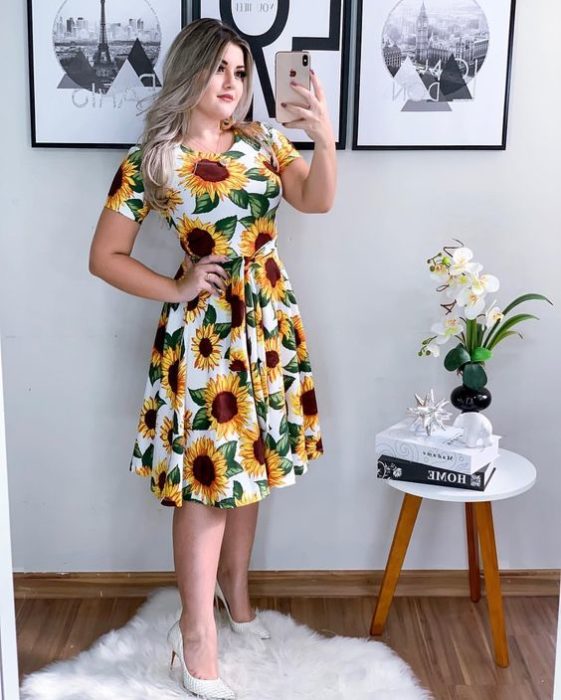 Chica lelvando vestido blanco con girasoles al frente