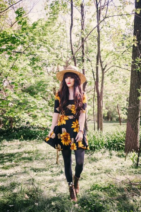 Chica llevando vestido negro con girasoles en estampado