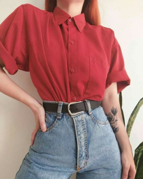 Chica usando mom jeans, cinturon negro y camisa color rojo cereza de manga corta