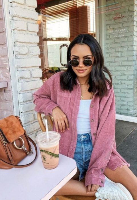 Outfit de pana en camisa rosa, top blanco, shorts denim y tenis blancos