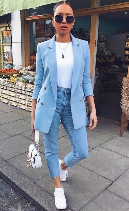 Chica usando jeans denim, blusa blanca, blazer color azul cielo y tenis blancos