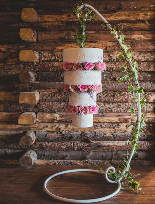 Pastel de bodas volteado pendiendo de un  armazón 