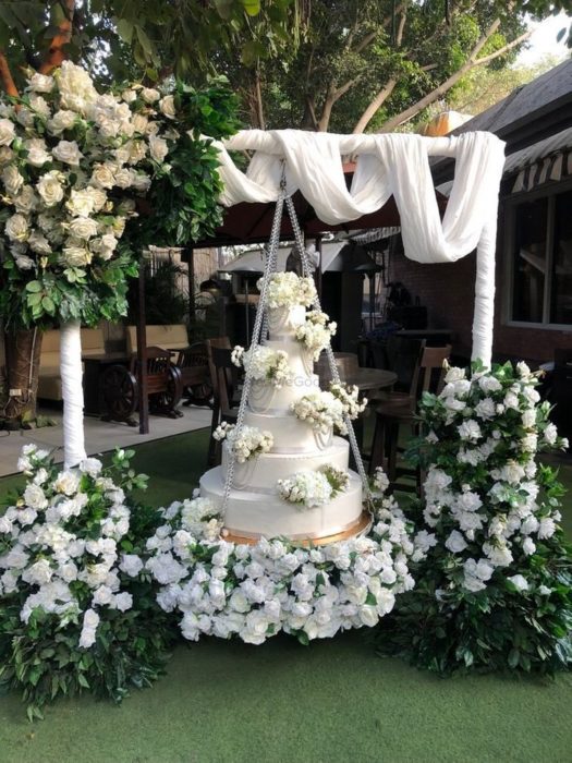 Pastel de bodas de cuatro pisos montado en un columpio