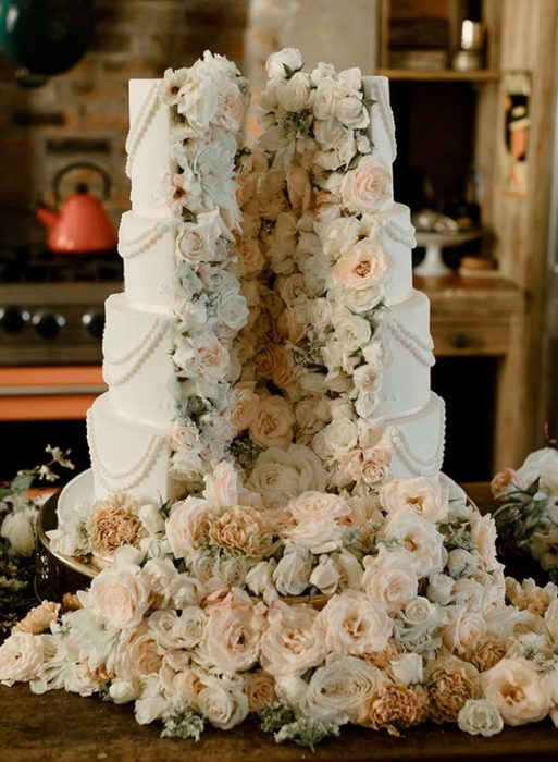 Pastel de bodas en color azul cielo con relleno de flores