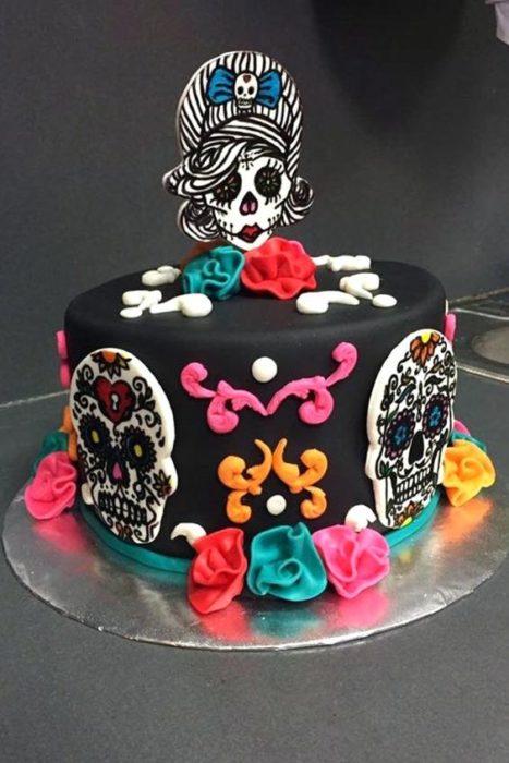 Pastel inspirado en el Día de muertos en color negro con galletas de mantequilla en forma de calavera