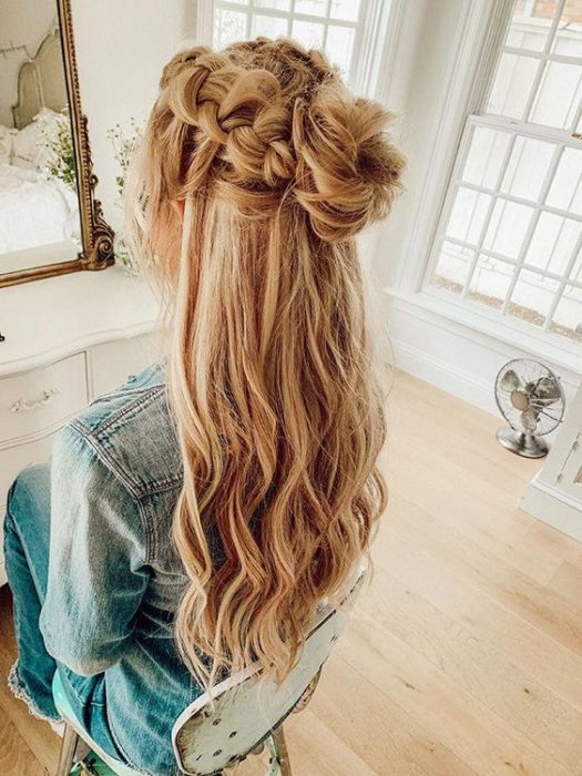 Chica con trenzas y un moñito recogido y el resto del cabello suelto