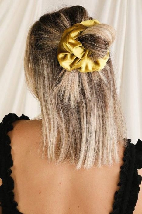 Chica con media coleta usando una scrunchie