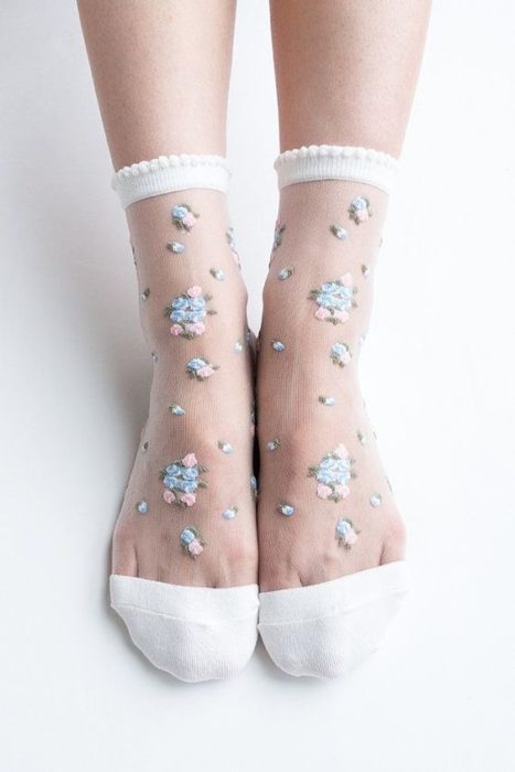 Pies con medias transparentes con flores azul pequeñas