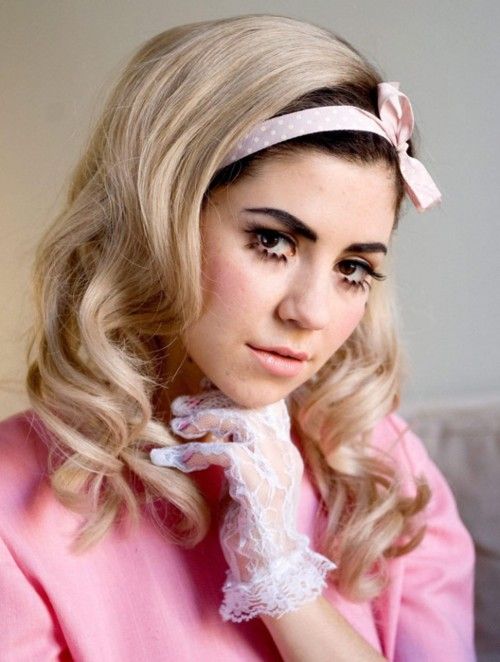 Marina Diamonds con lazo rosa con moño en la cabeza y guantes rosas con transparencias