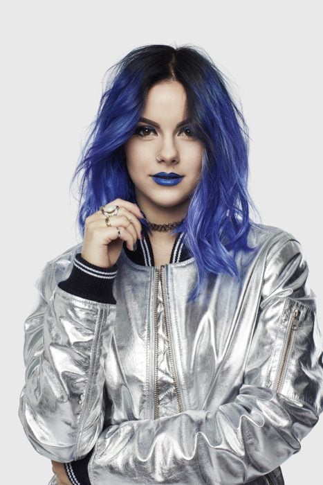 Chica con el cabello de color azul  y una chaqueta color plateada 