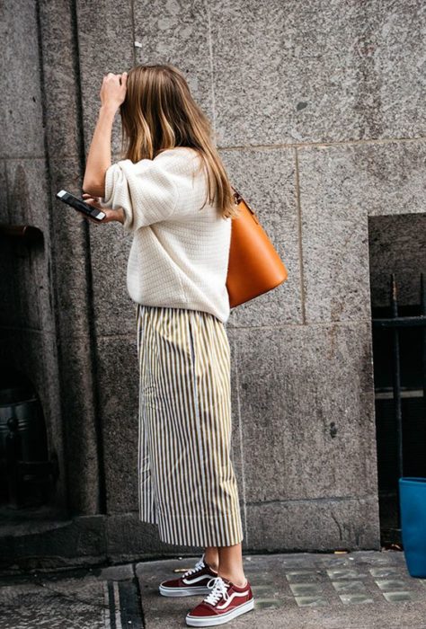 Chica usando suéter holgado color blanco y maxi falda larga